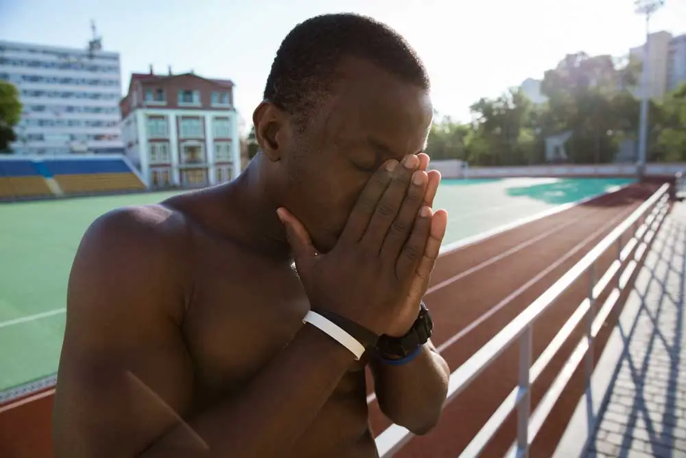 Tired sportsman leaning on track